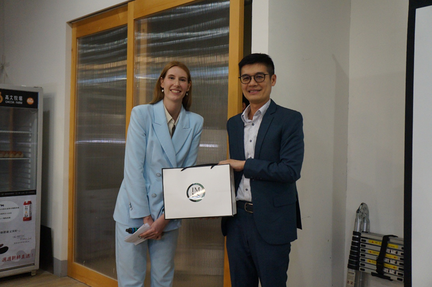 Student Council President Zoe Weaver presents an IMES souvenir to Andrew Hsu, Managing Partner of Deloitte